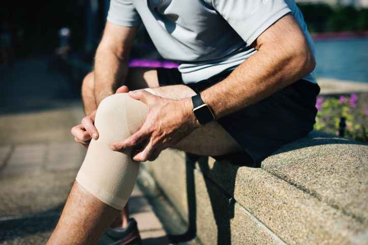 person seating on bench while holding knees