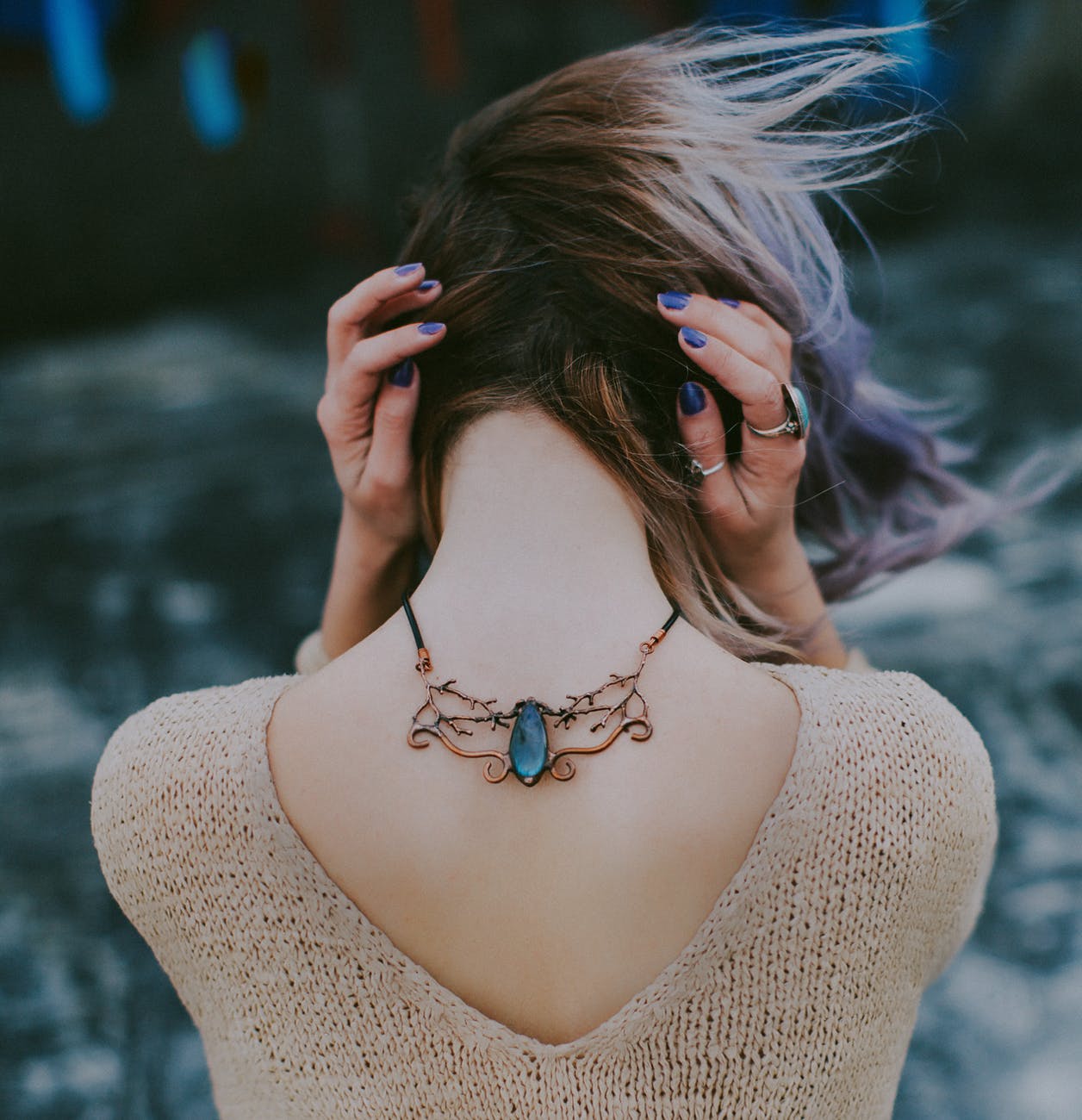 woman wears gold colored blue gemstone pendant necklace