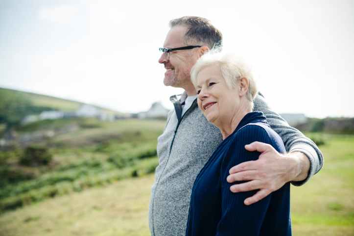 smiling man holding woman s left shoulder