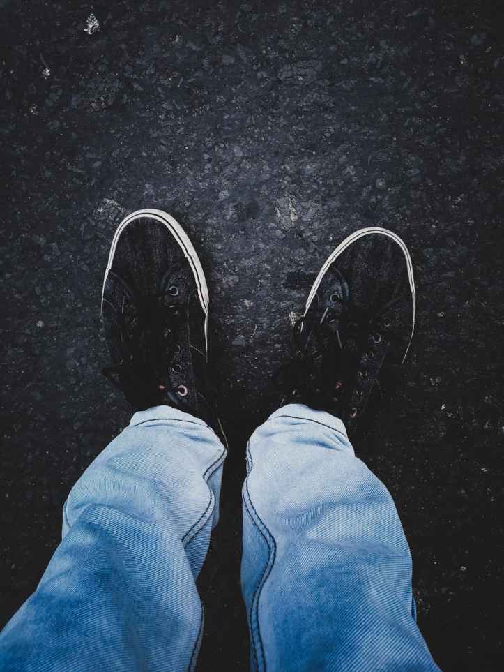 person in pair of black low top sneakers