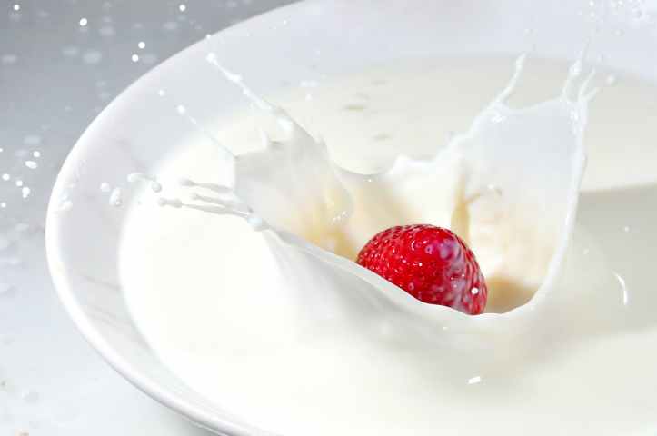 time lapse photography of strawberry falling on milk