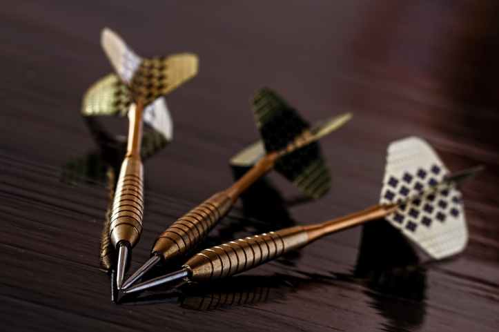 brass gold darts on brown table