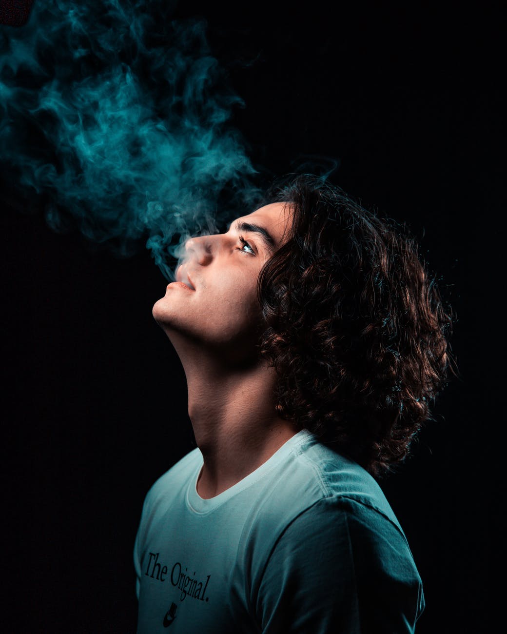 photo of man smoking in black background