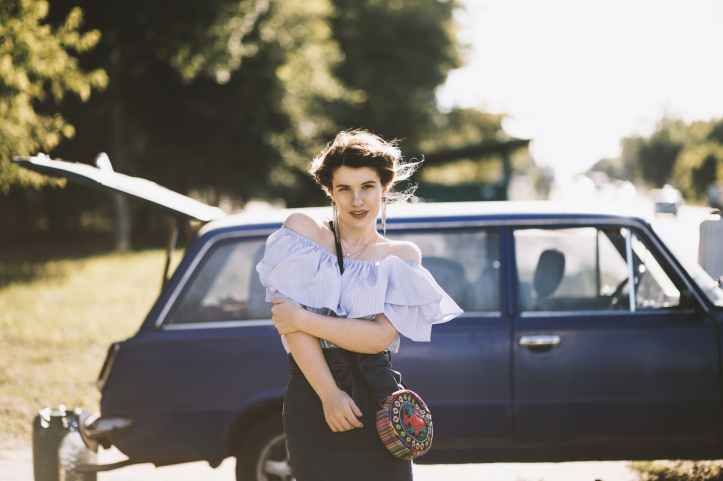woman standing near blue vehicle