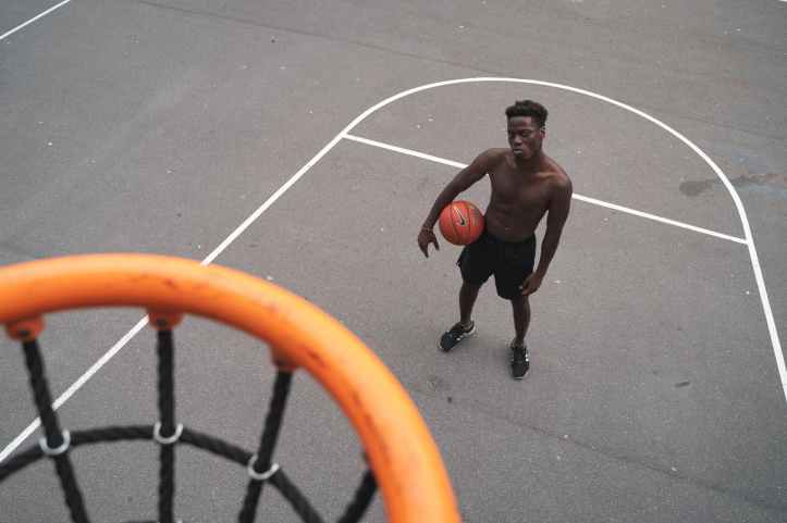 man standing near basketball hoop holding a basketbal