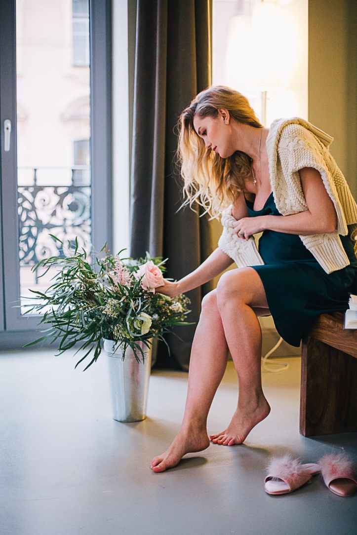 woman sitting on bench while picking up rose