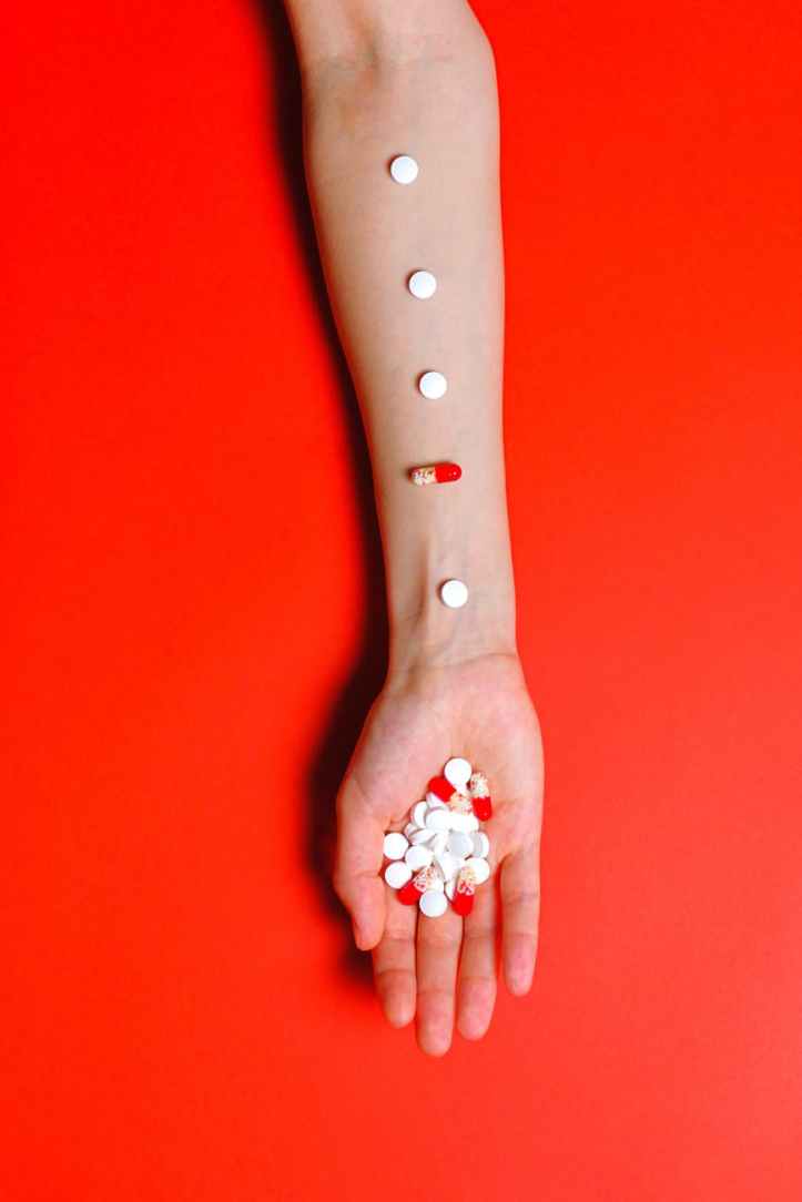 person holding white and red medication pills