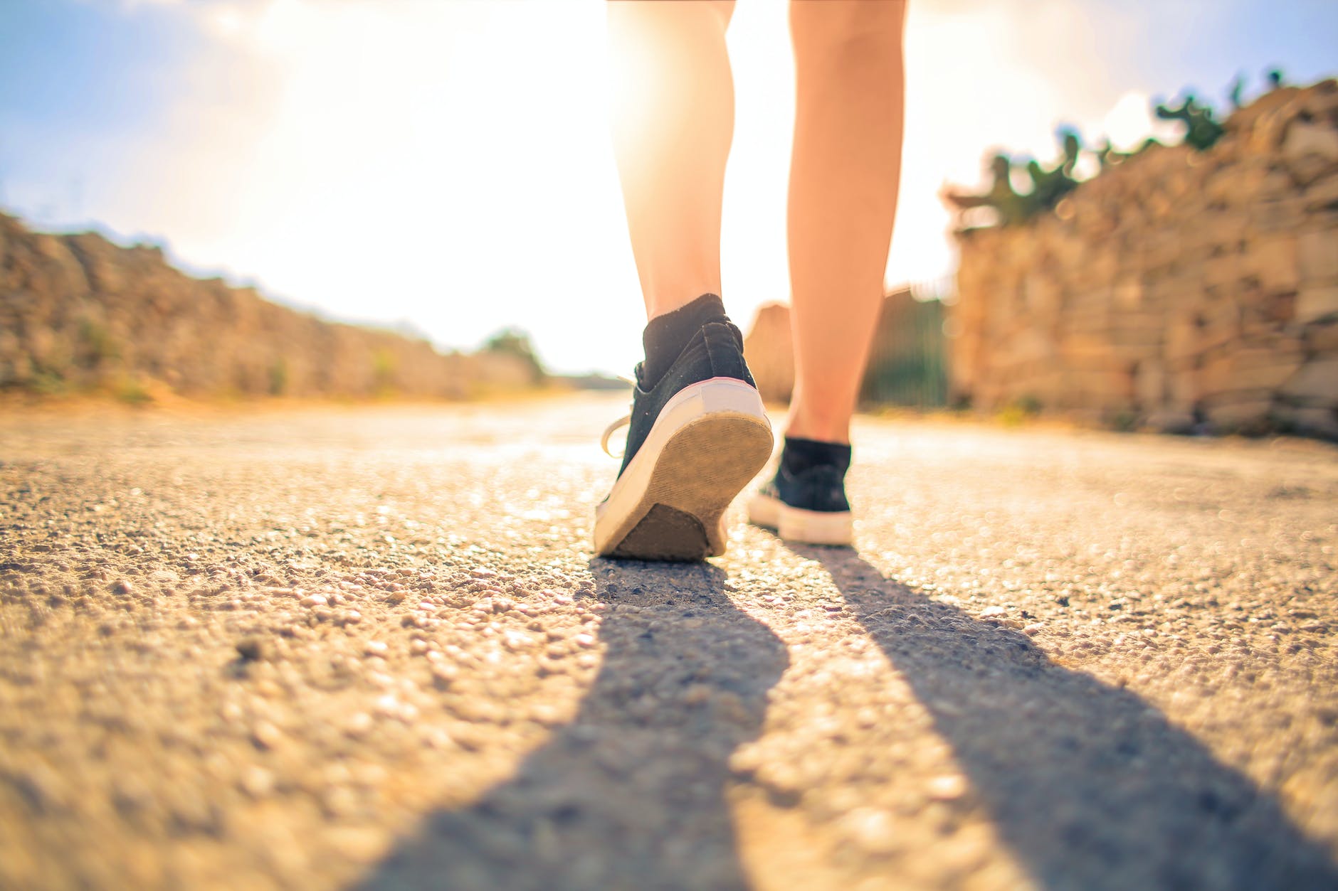 femme marchant sur le chemin sous le soleil