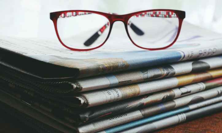 lunettes encadrees rouges sur les journaux