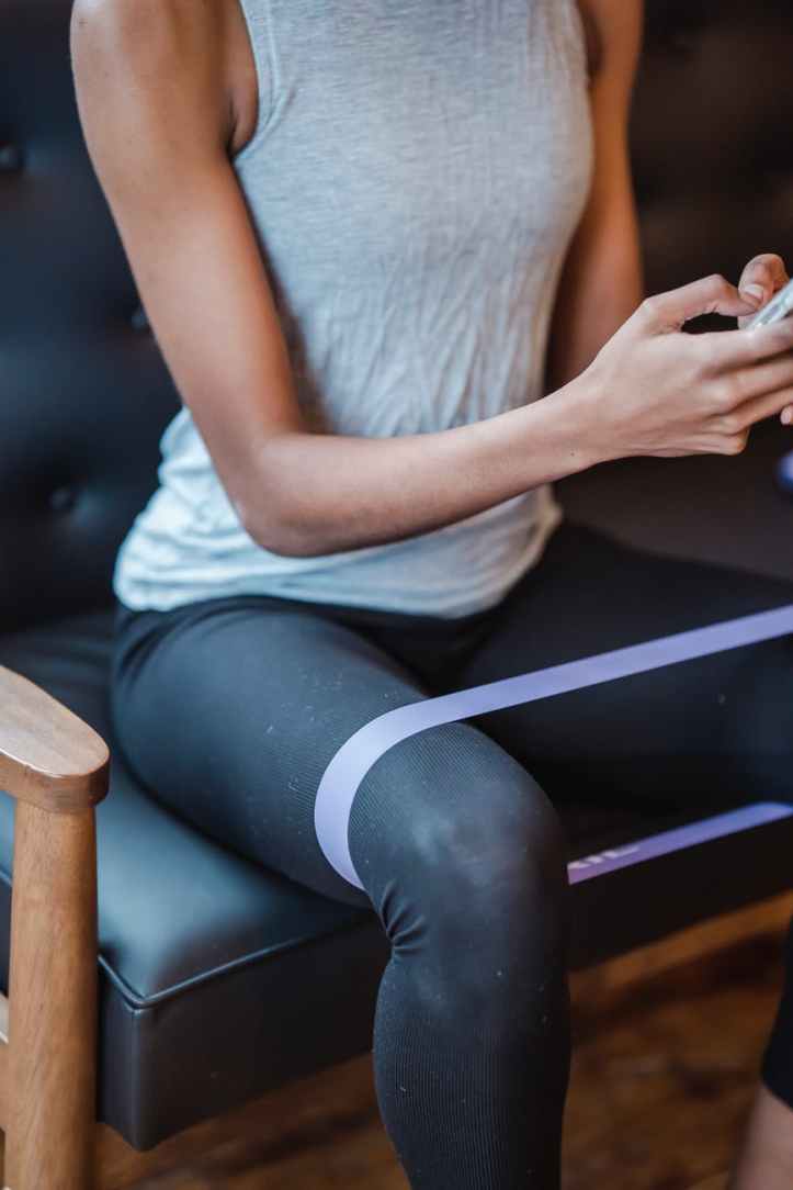 femme en chemise blanche et leggings noirs assis sur une chaise noire