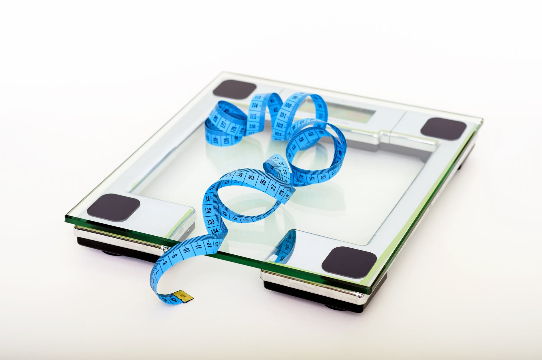 ruban bleu mesurant sur une balance carree en verre transparent